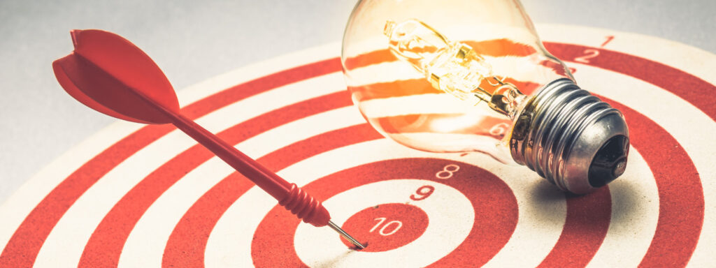 Bullseye target with lightbulb signafying goal setting at ActionCOACH